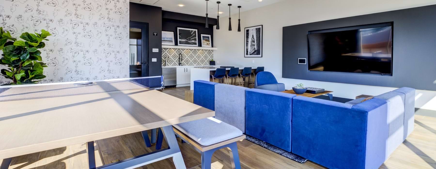 a clubroom with a table, couch and tv